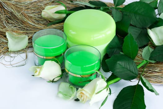Set of three green cosmetic cream bottles with white roses