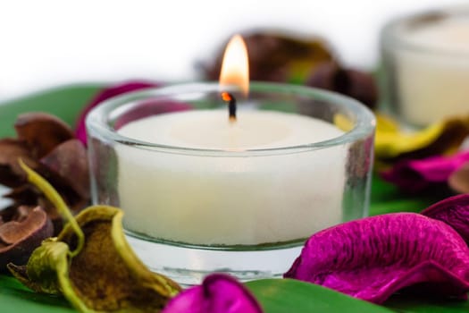 Composition of burning candles fragrant potpourri on monstera leaf