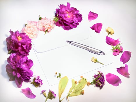 Flowers, envelope and pen on a white background