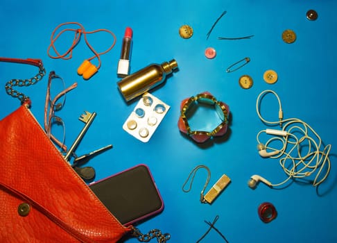Top view of female accessories and smart phone on yellow background