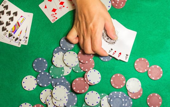 The male hands with cards in casino and chips