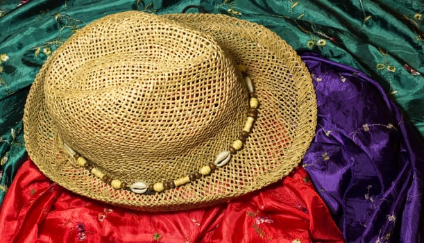 The stylish summer beach accessories. Vacation mood. Straw hat, and silk scarfes