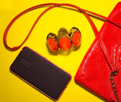 Top view of female accessories and smart phone on blue background