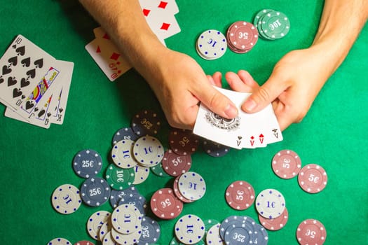 The male hands with cards in casino and chips