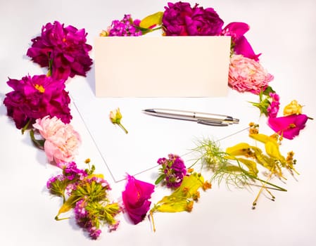 Flowers, envelope and pen on a lilac background