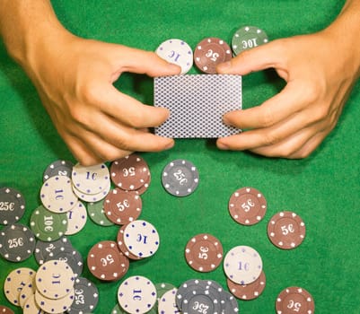 The male hands with cards in casino and chips