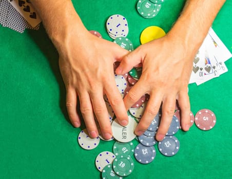 The male hands with cards in casino and chips