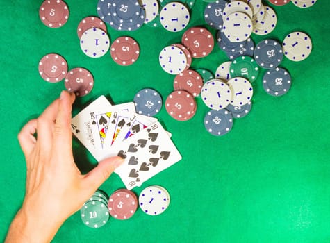 The male hands with cards in casino and chips