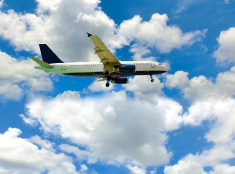 The airplane in the blue sky with clouds