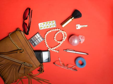 Top view of the female accessories and phone on a red background