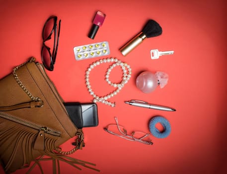 Top view of the female accessories and phone on a red background