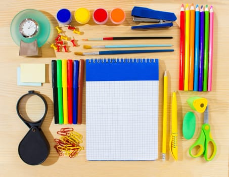 School items making a frame on wooden background with a space for your text. Top view.