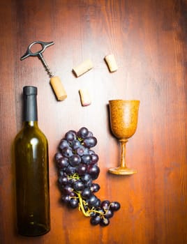 The empty bottle of wine with corkscrews and glass of coconut on wooden background