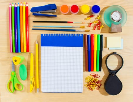 School items making a frame on wooden background with a space for your text. Top view.