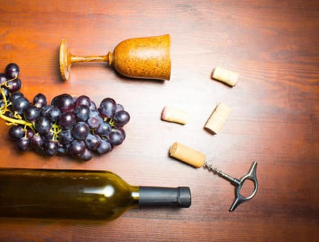 The empty bottle of wine with corkscrews and glass of coconut on wooden background