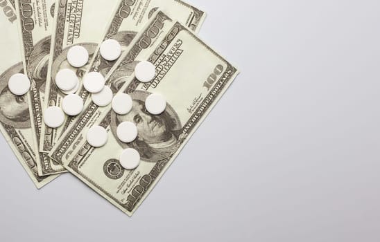 White pills and money, health expense concept, health care cost, medical business