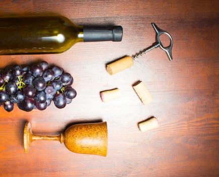 The empty bottle of wine with corkscrews and glass of coconut on wooden background
