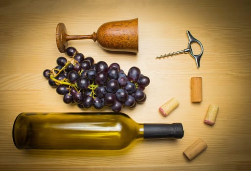 The empty bottle of wine with corkscrews and glass of coconut on wooden background