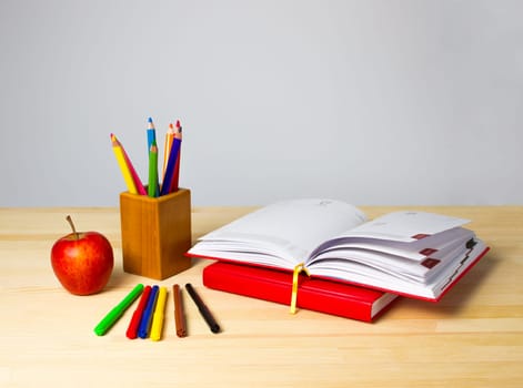 Back to school background with books, pencils and red apple over wooden table