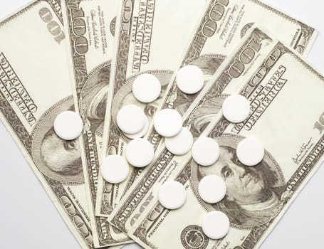White pills and money, health expense concept, health care cost, medical business