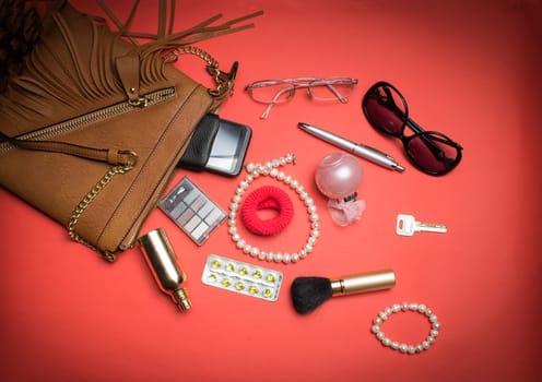 Top view of the female accessories and phone on a red background