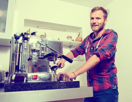 young bearded man in checkered shirt with his espresso machine