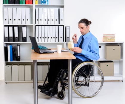 disabled business man in wheelchair eating in the office