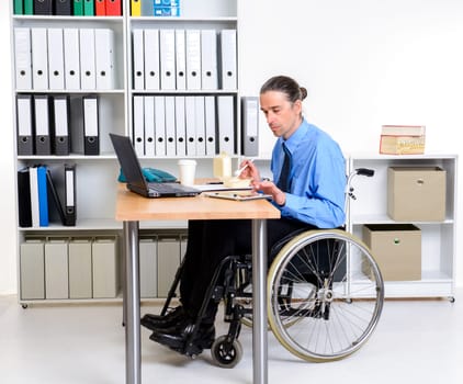 disabled business man in wheelchair eating in the office