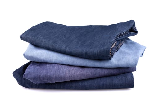 Stack of jeans on white background.