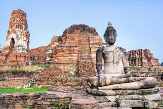 Ancient ruins of pagoda and old buddha statue at Wat Phra Mahathat temple is a famous attractions in Phra Nakhon Si Ayutthaya Historical Park, Thailand