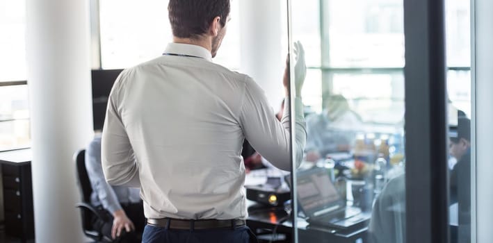 Business man making a presentation at office. Business executive delivering a presentation to his colleagues during meeting or in-house business training, explaining business plans to his employees.