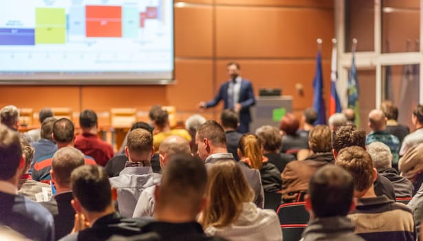 Speaker giving a talk in conference hall at business event. Audience at the conference hall. Business and Entrepreneurship concept.
