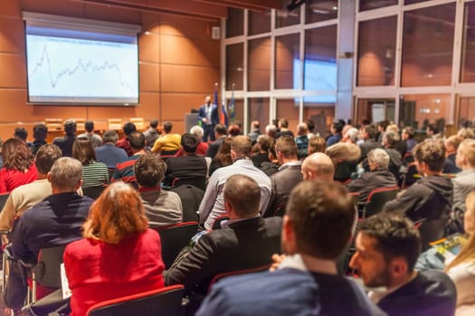 Speaker giving a talk in conference hall at business event. Audience at the conference hall. Business and Entrepreneurship concept.