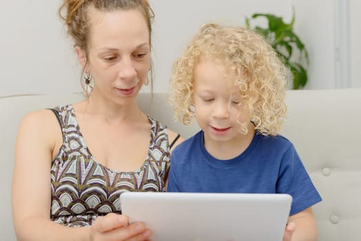 a blond little boy and his mom with a digital tablet