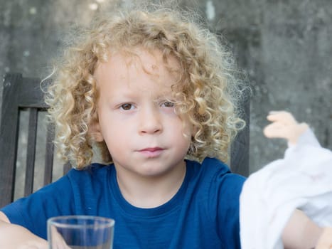a portrait of a little boy with blond curly hair