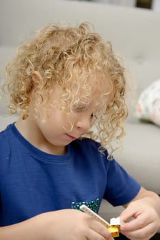 a little blond boy playing with toys