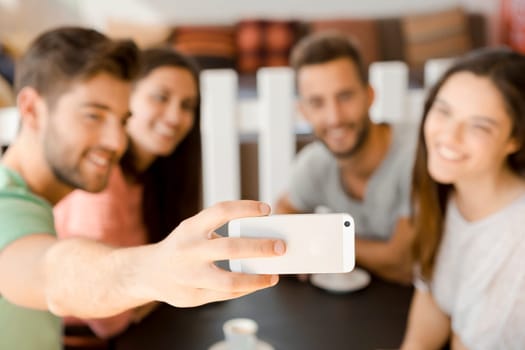 Group of friends at the coffee shop making a selfie together