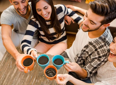 Group of friends making a toast with coffee