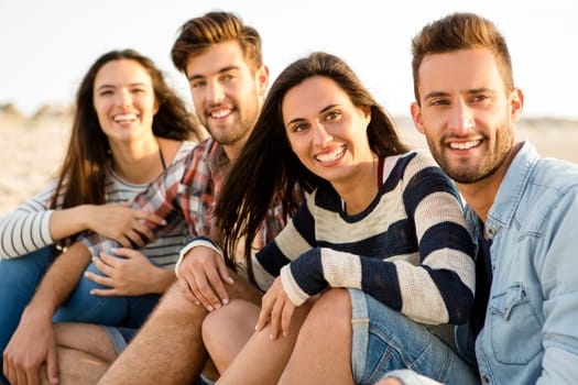 Multicultural group of friends at the beach having fun
