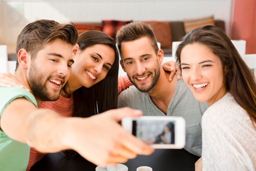 Group of friends at the coffee shop making a selfie together