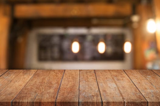 Brown wooden table top with coffee shop blurred abstract background