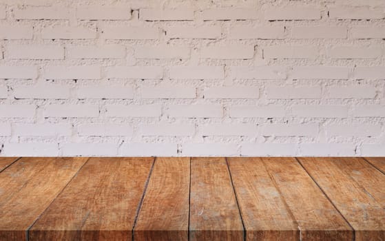 Brown wooden table top with white brick wall decorated in coffee shop