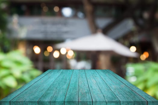 Perspective blue wooden table top with cafe blurred abstract background