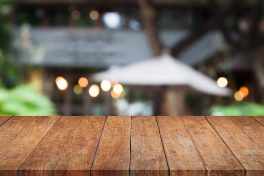 Perspective brown wooden table top with cafe blurred abstract background