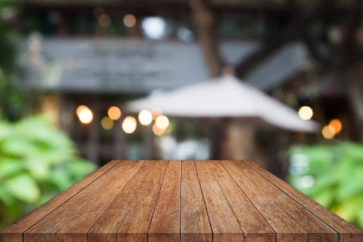 Perspective wooden table top with cafe blurred abstract background