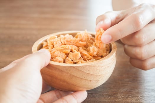 Fried shrimp chins snack in wooden bowl, stock photo