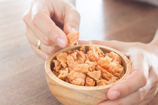 Fried shrimp chins snack in wooden bowl, stock photo