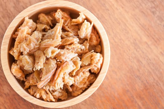 Fried shrimp chins snack in wooden bowl, stock photo