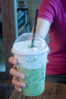 Take-home ice coffee cup on wooden table, stock photo