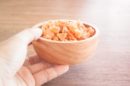 Fried shrimp chins snack in wooden bowl, stock photo